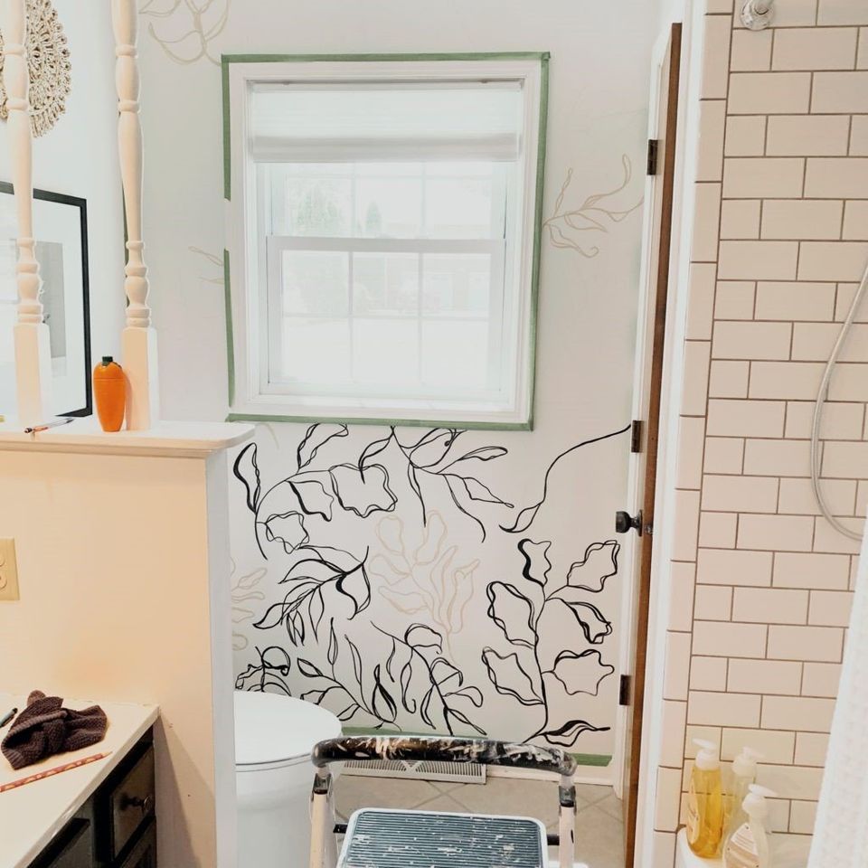 Process of painting mural on white bathroom wall