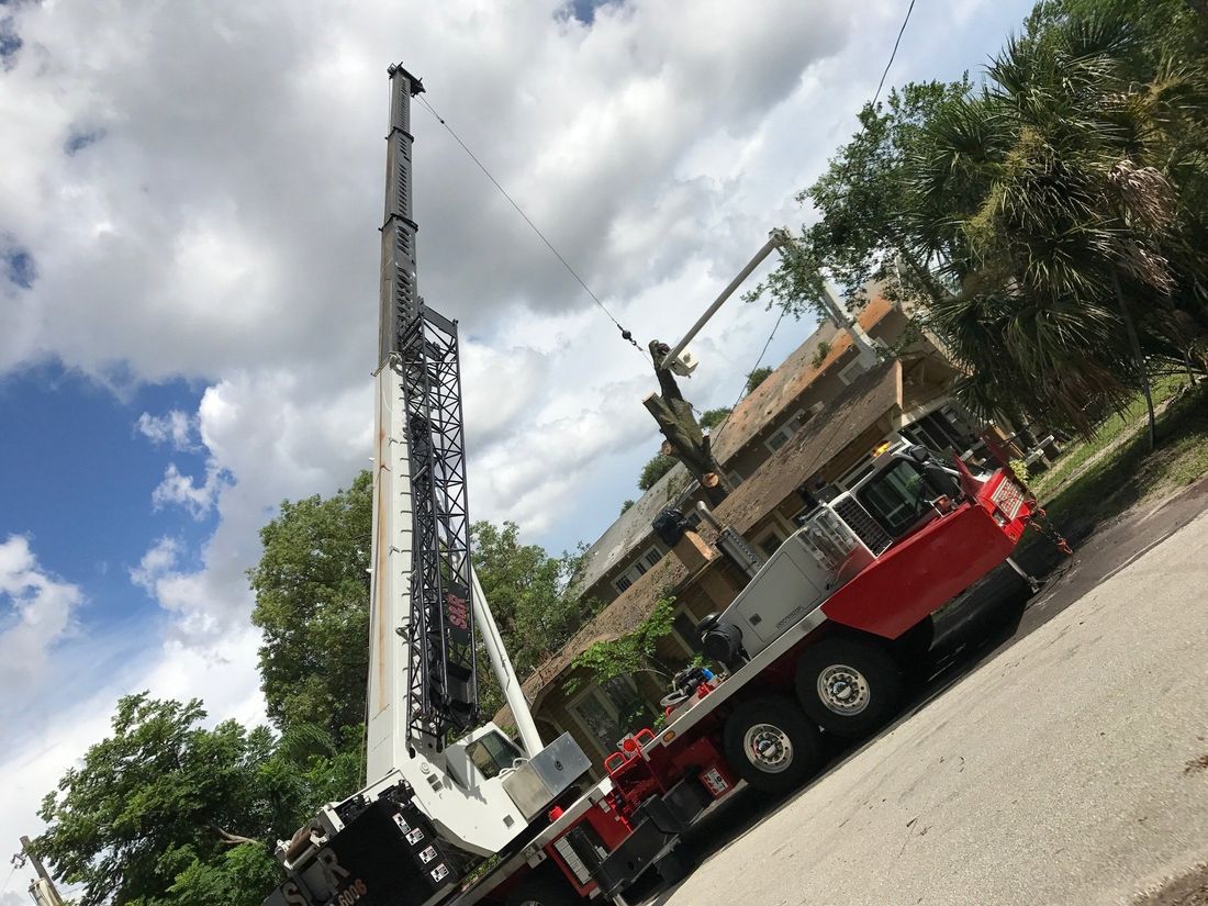 A large crane is parked in front of a house