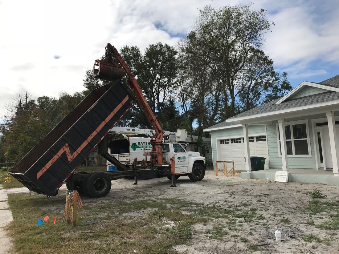 A dump truck is parked in front of a house.
