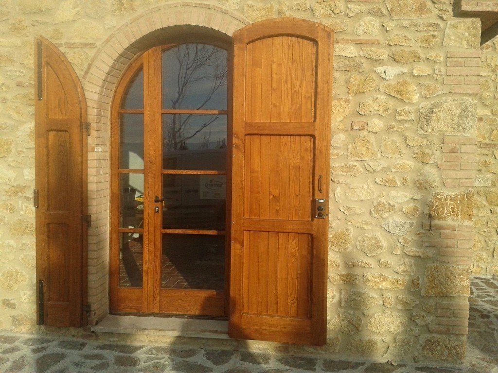 una porta da esterno in legno ad arco