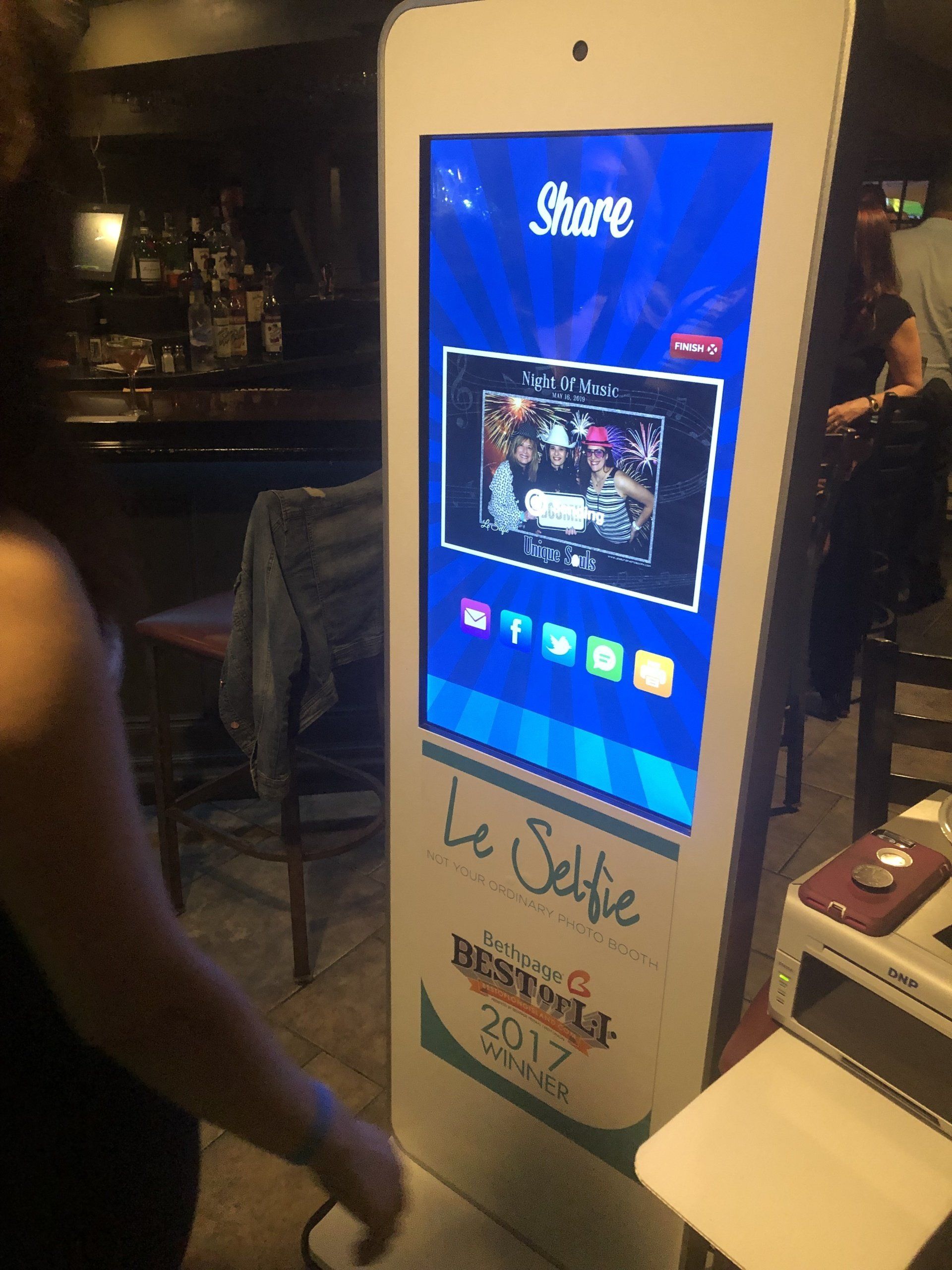 A woman is standing in front of a selfie machine
