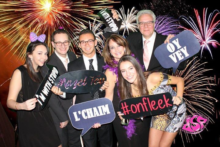 A group of people holding signs in front of fireworks.