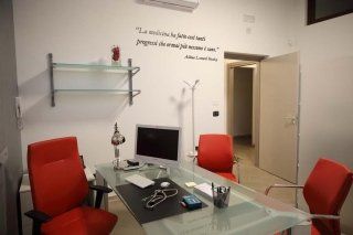 una sala conferenza con un tavolo e tre sedie rosse
