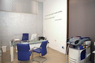 una scrivania con tre sedie e accanto un apparecchio medico
