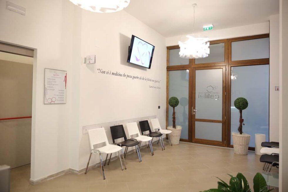 una sala di attesa con le sedie e un monitor al muro