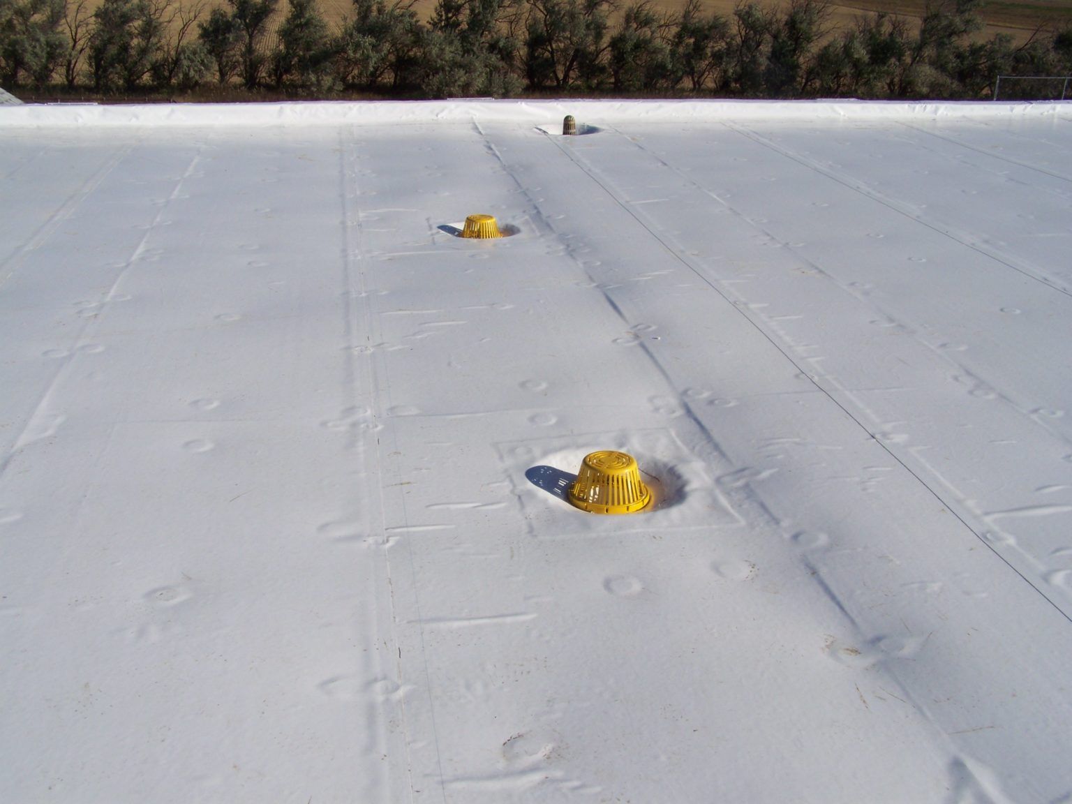 a white roof with yellow drains on it .