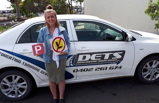 girl standing next to car with license