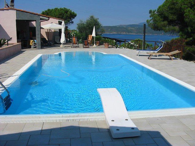 Piscina con bordo sfioratore e trampolino