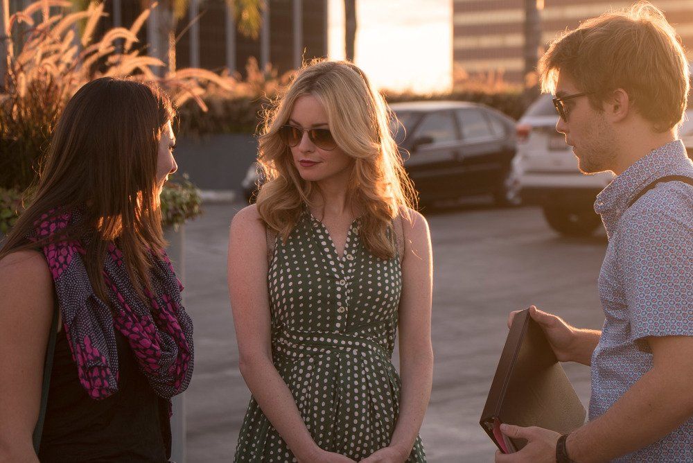 A group of people are standing next to each other in a parking lot.