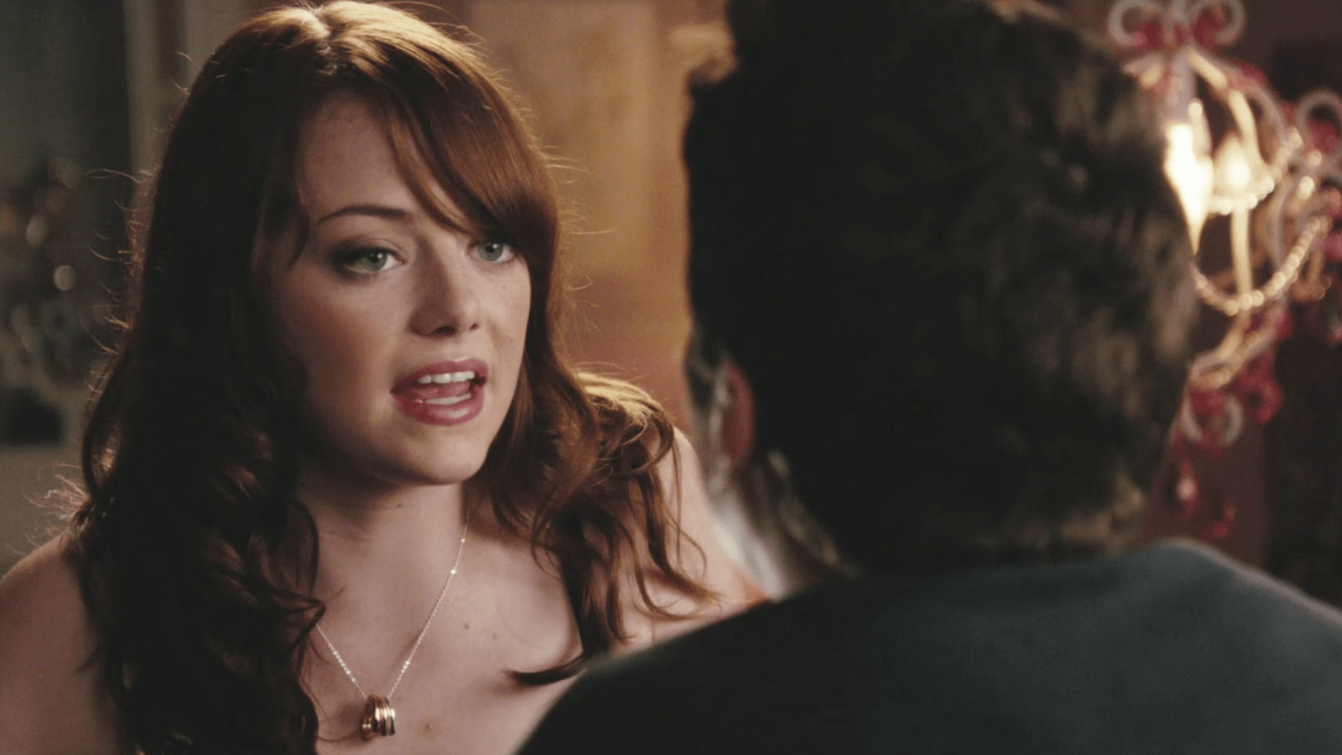 A woman is talking to a man in a dark room.