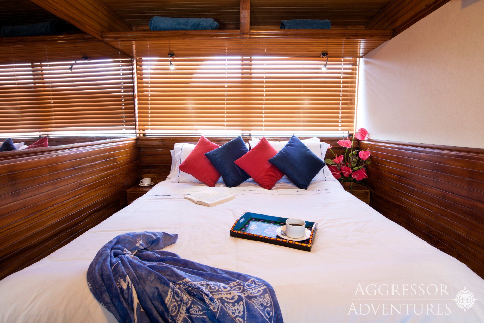 Bedroom with a bed, pillows, and tray, with wood paneling and window blinds.