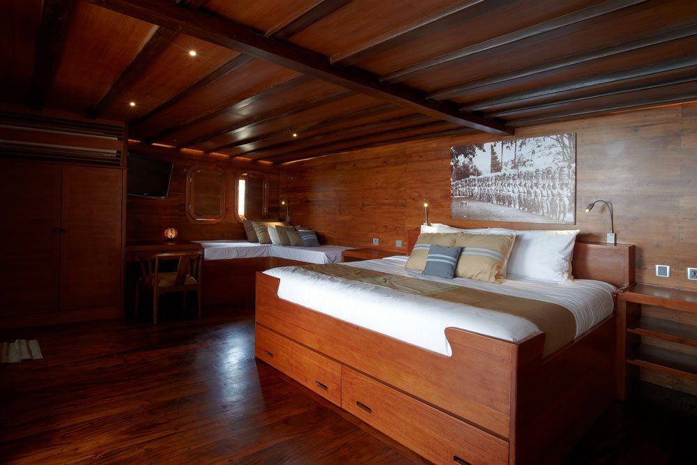 Wooden cabin interior with beds and wood paneling.