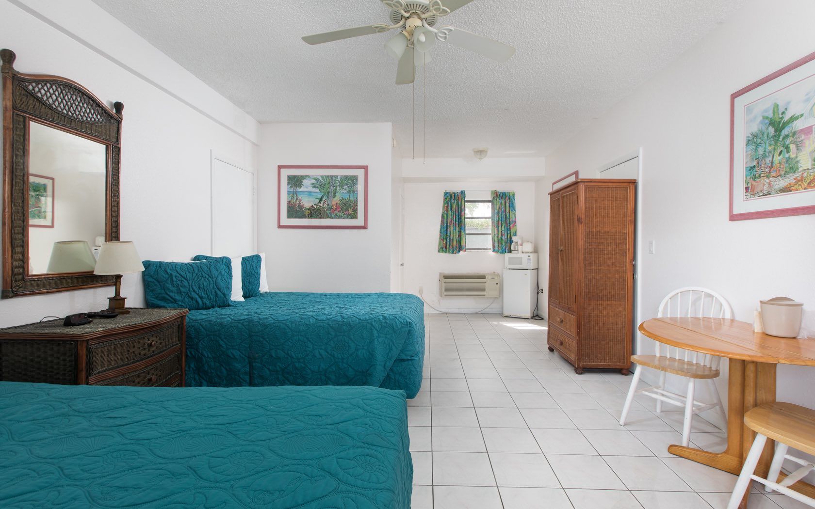 Hotel room with two twin beds, small table and chairs, and a wardrobe.