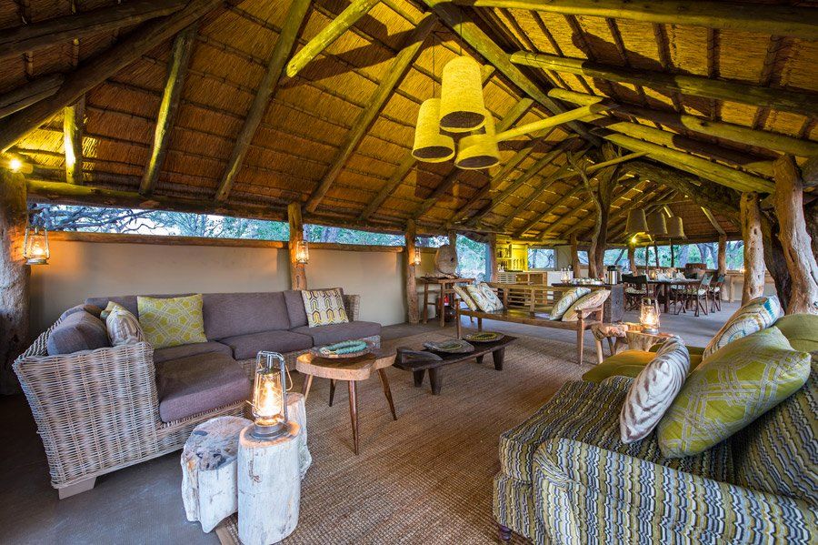 Open-air lounge with thatch roof, wicker furniture, and decorative lanterns.