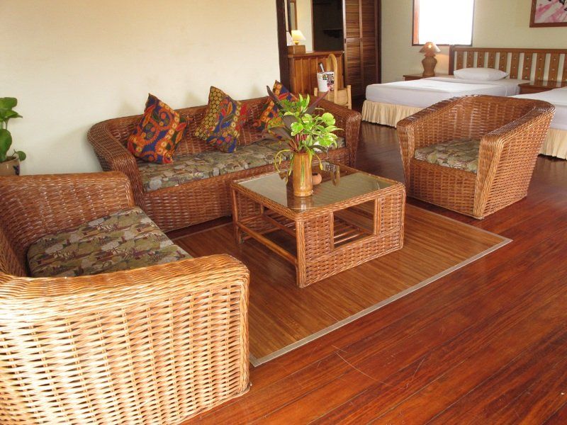 Living room with wicker furniture and hardwood floors.