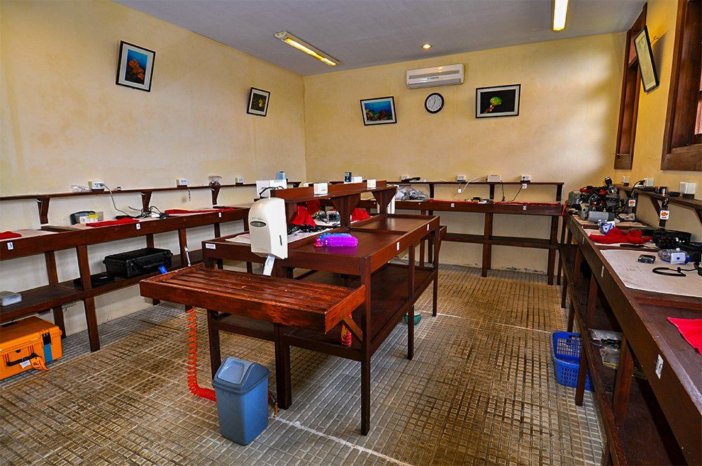 Workshop interior with work tables and tools, neutral-toned walls, and artwork.