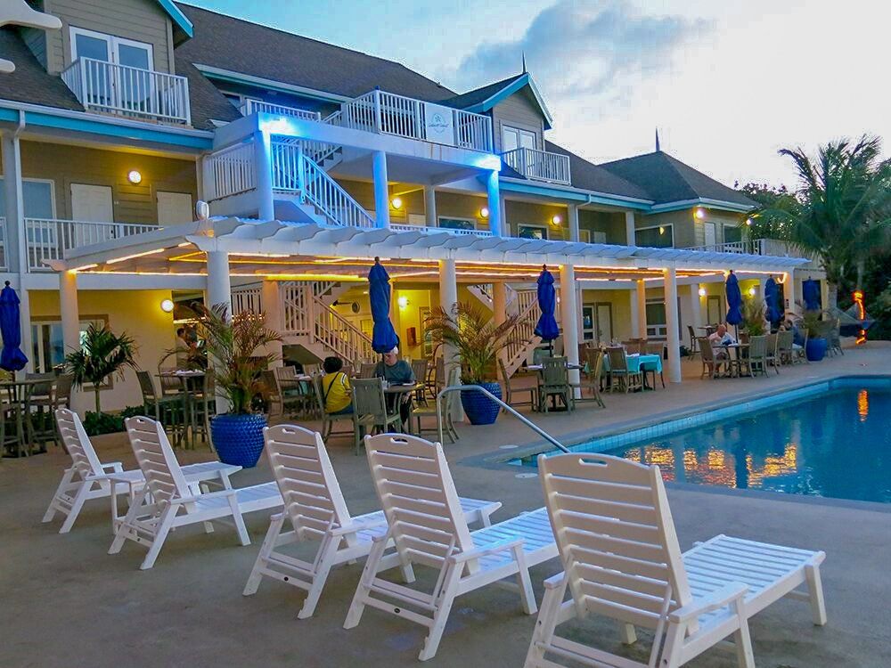 Hotel exterior with pool, outdoor seating, and blue accents.