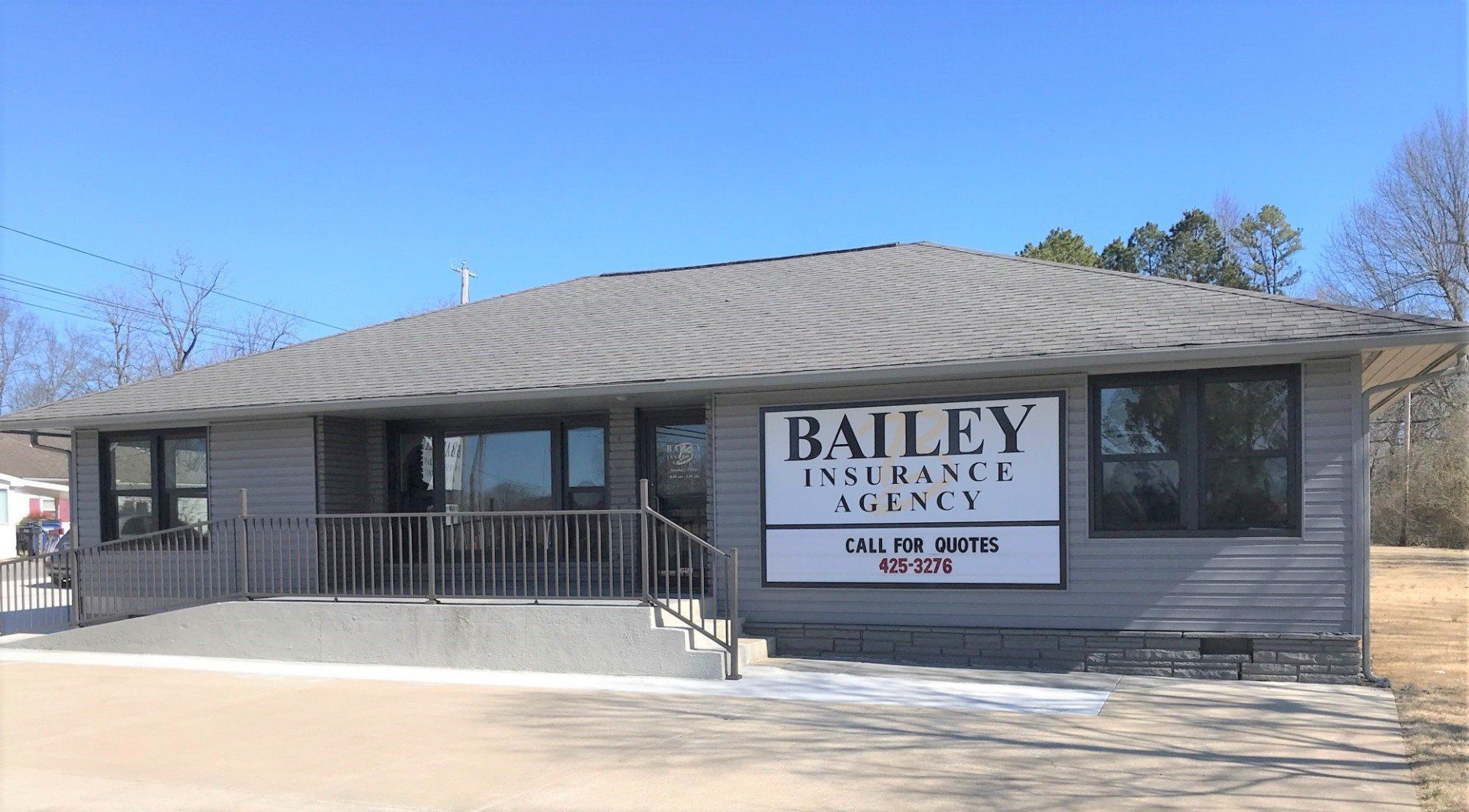 Bailey Insurance Group Agency in Mountain Home Arkansas office building with sign, gray exterior, and blue sky above