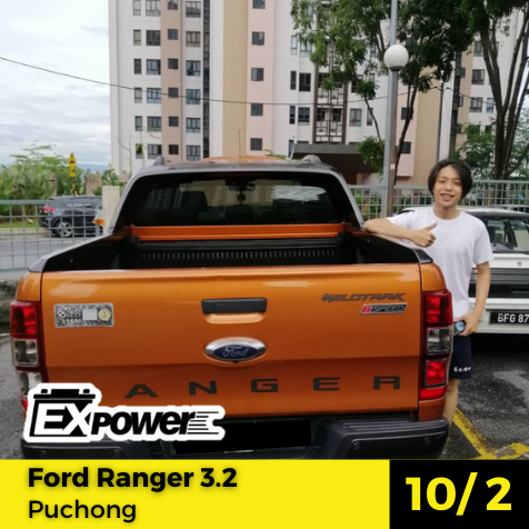 Orange Ford Ranger pickup parked outdoors, with a person standing beside it and auction-style text overlay.