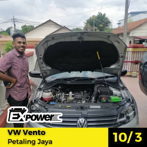 Man standing beside open-hood gray VW Vento with engine bay exposed at Petaling Jaya workshop