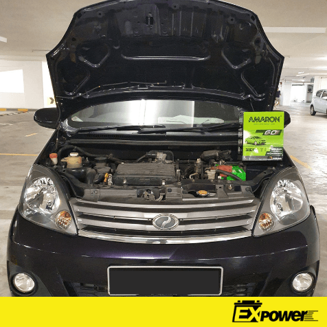 Black car with hood open in a parking garage, engine exposed and a green Expower sign on the right