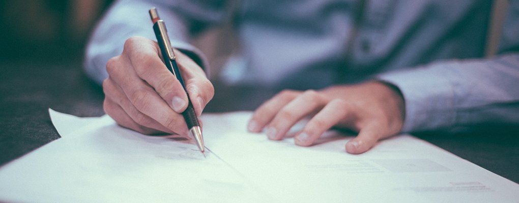 closeup of male hand signing contract