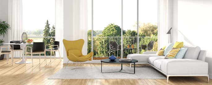 Modern living room with a bright yellow chair, white couch, and large windows