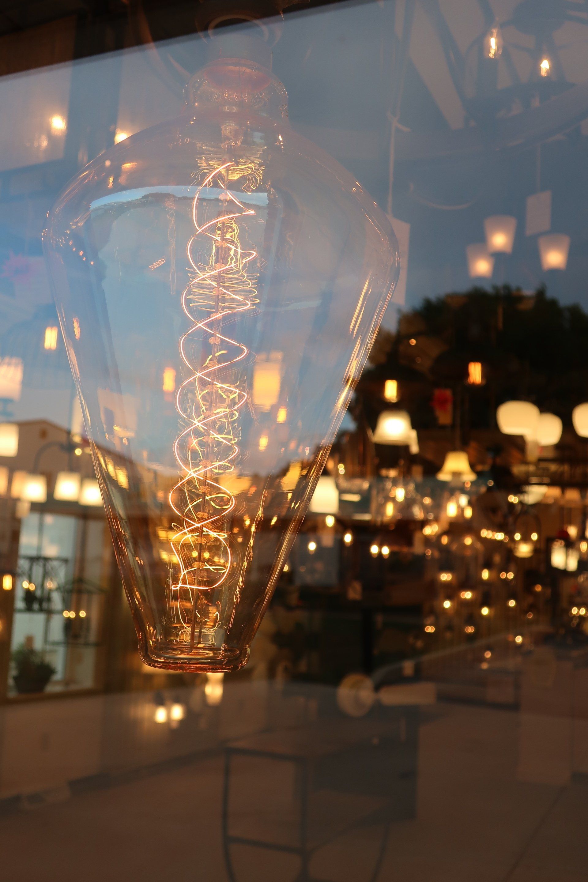 A light bulb is reflected in a glass window.
