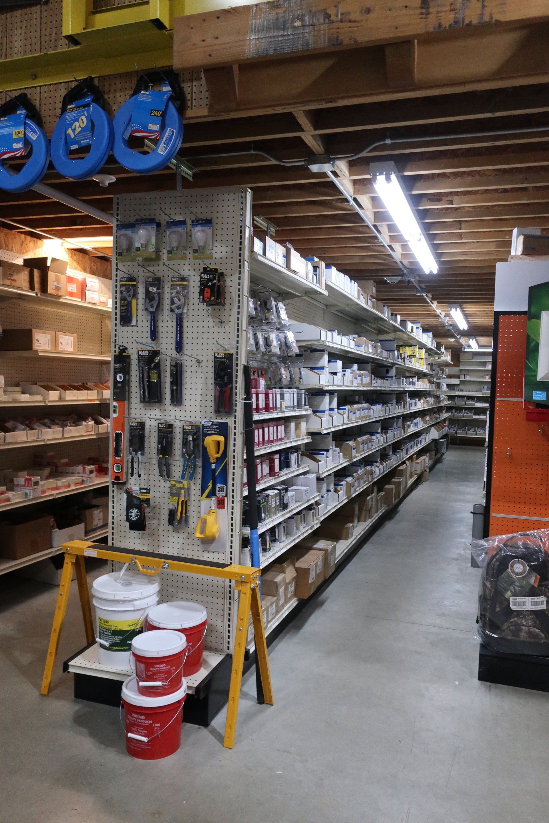 A store filled with lots of shelves and buckets of paint.