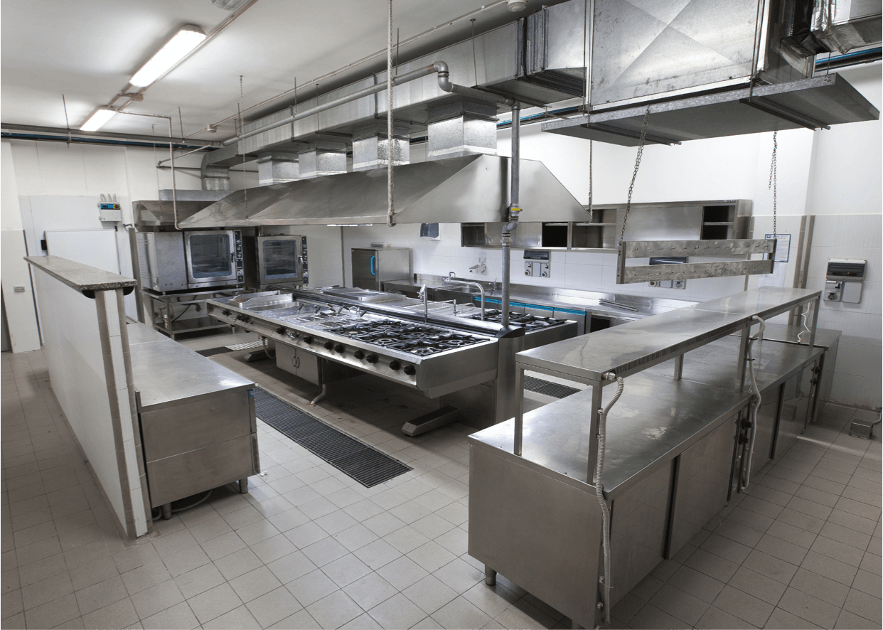 Commercial kitchen with stainless steel appliances, ventilation hoods, and tiled floor.