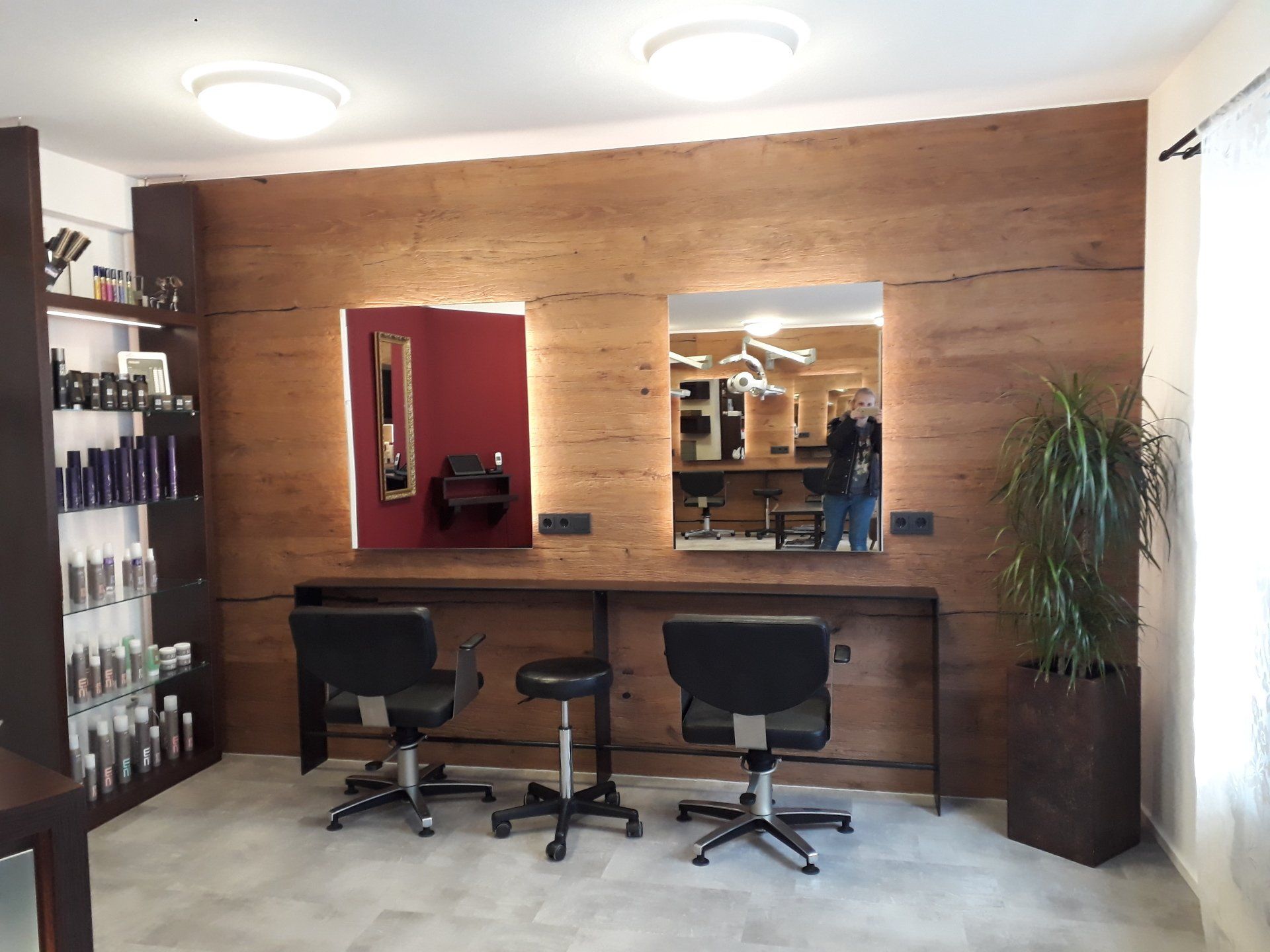 Ein Friseursalon mit zwei Stühlen und einem Spiegel.