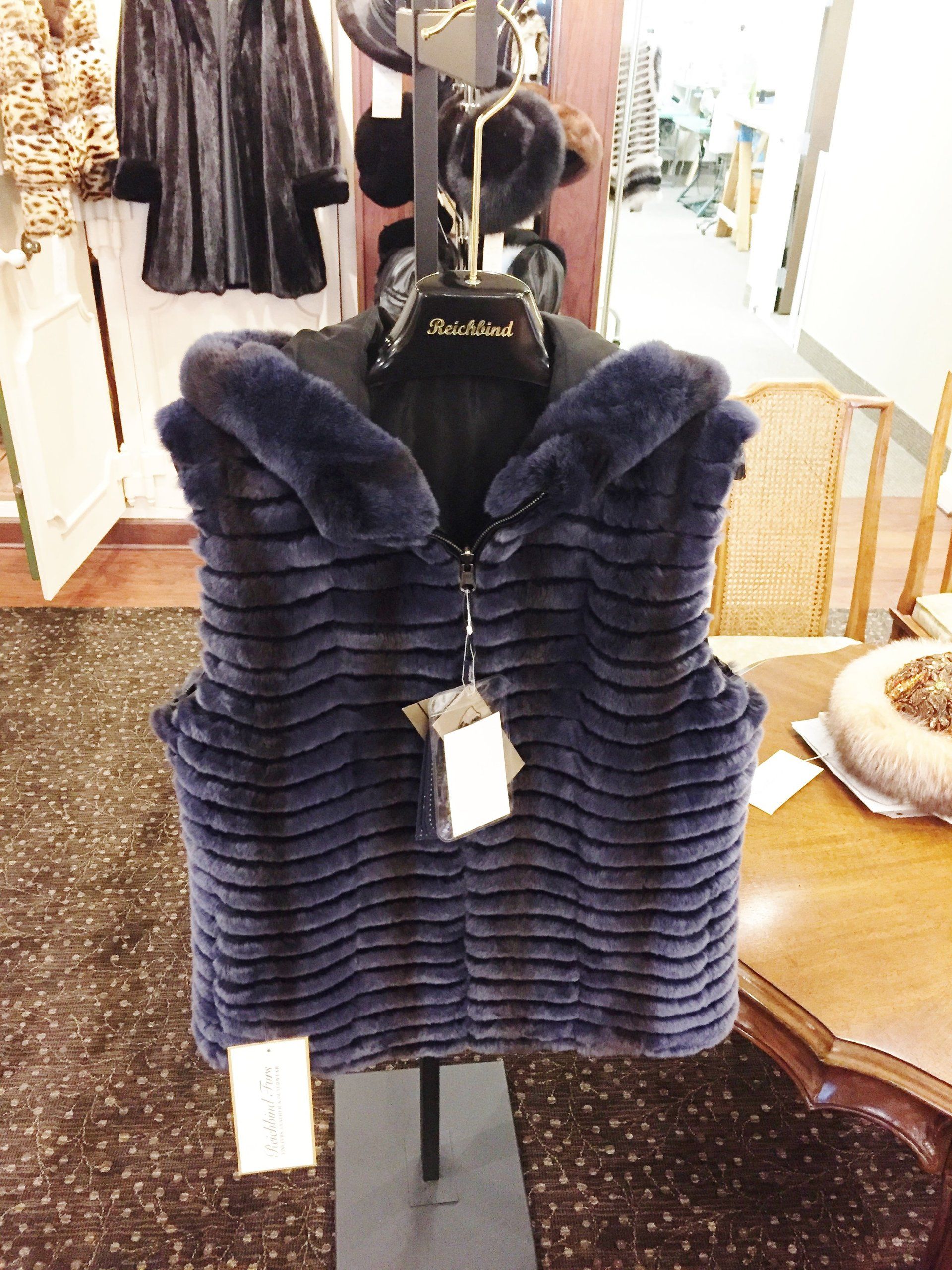 A blue fur vest is on display in a store
