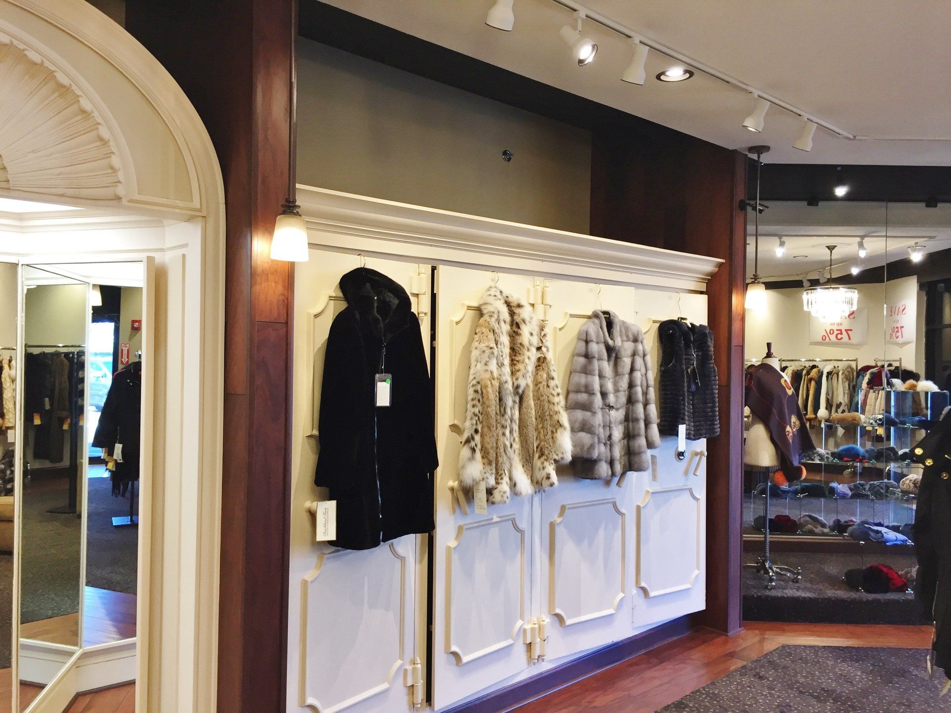 A row of fur coats hanging on a wall in a store