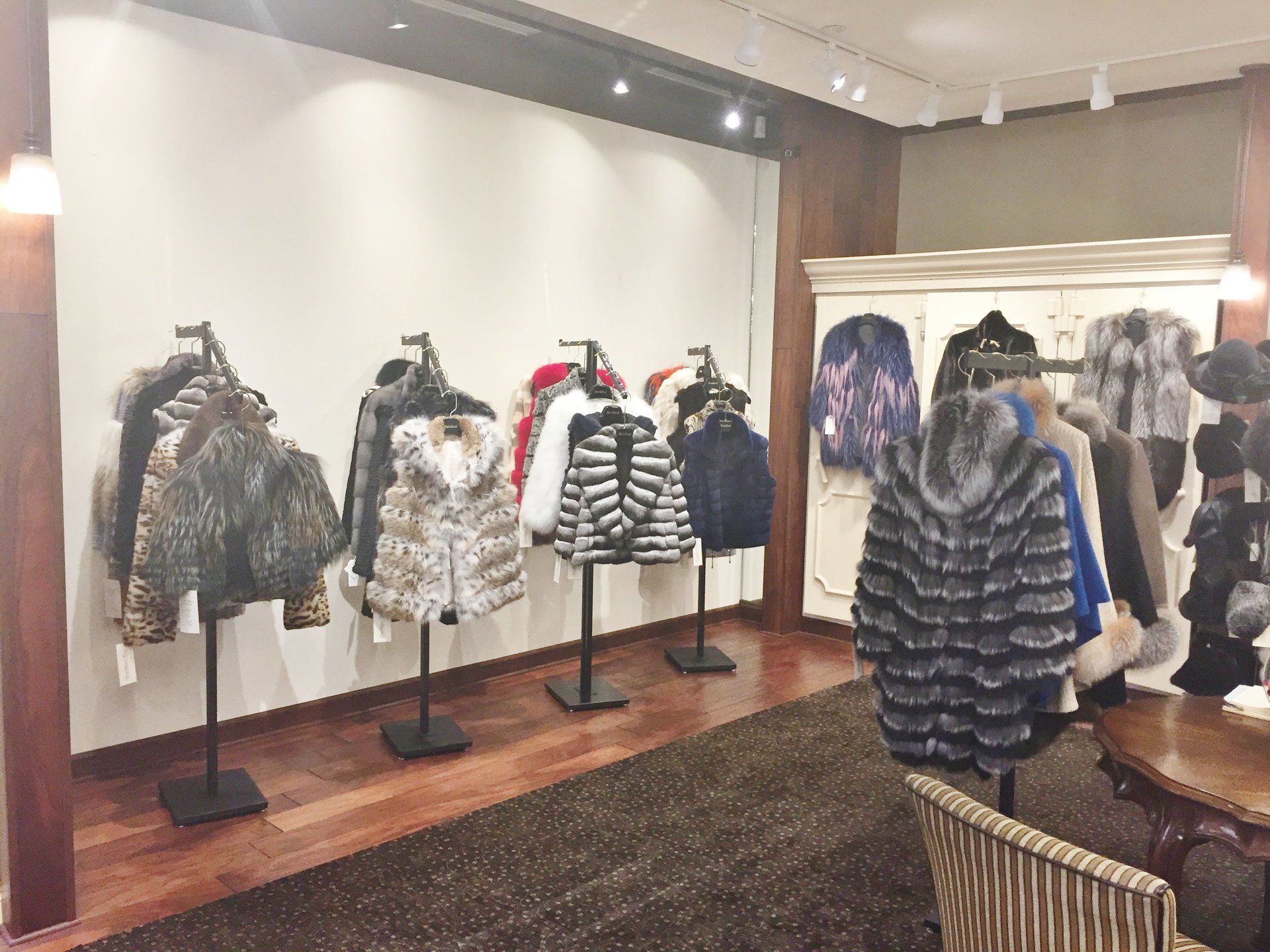 A room filled with lots of fur coats on display.