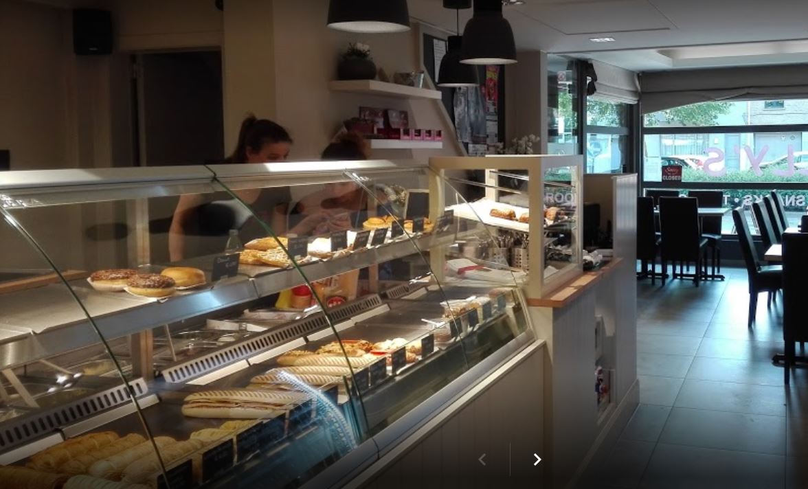 Een bakkerij met een glazen vitrine gevuld met etenswaren.