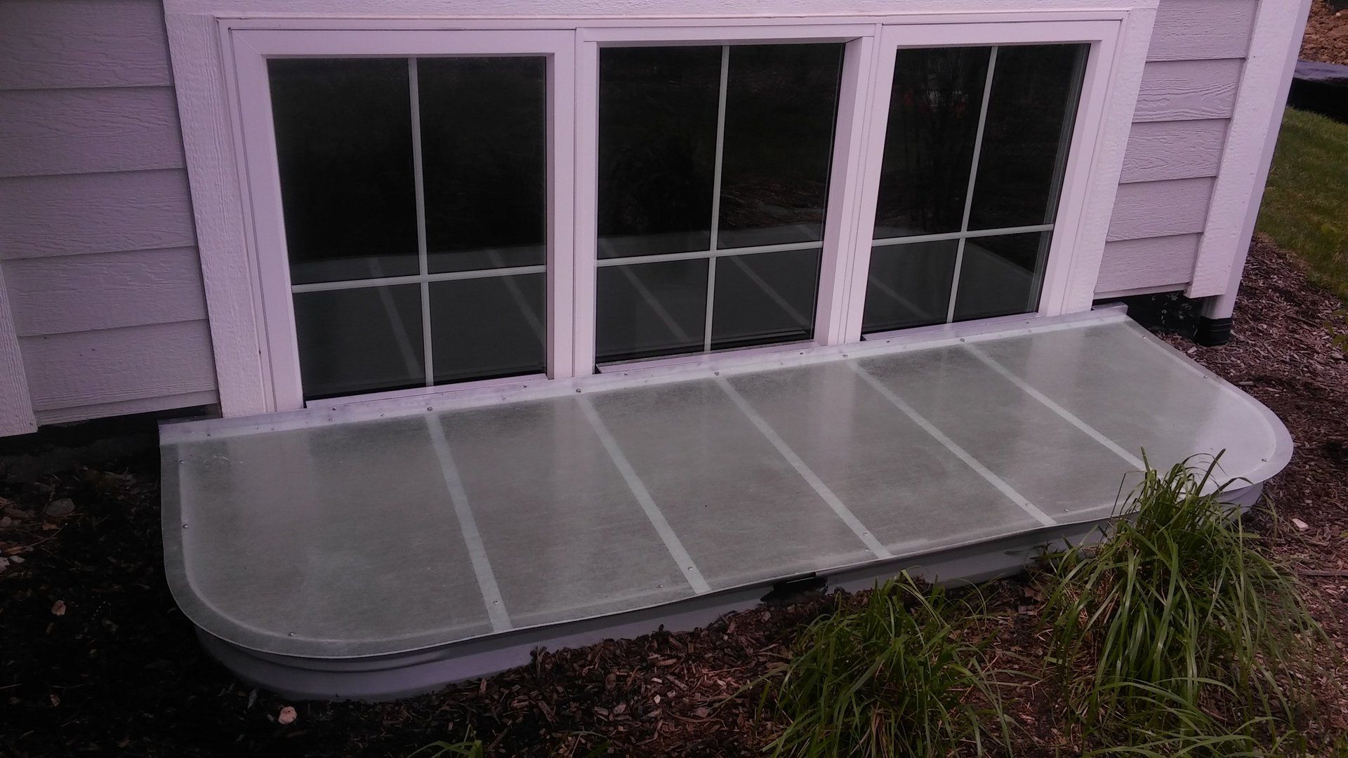 A white house with a window that is covered in plastic.