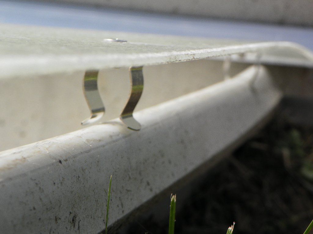 A close up of a metal clip on a white surface.