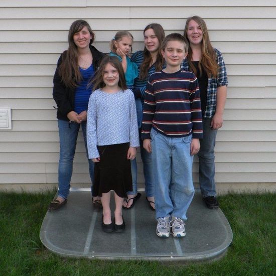 A group of people posing for a picture in front of a house
