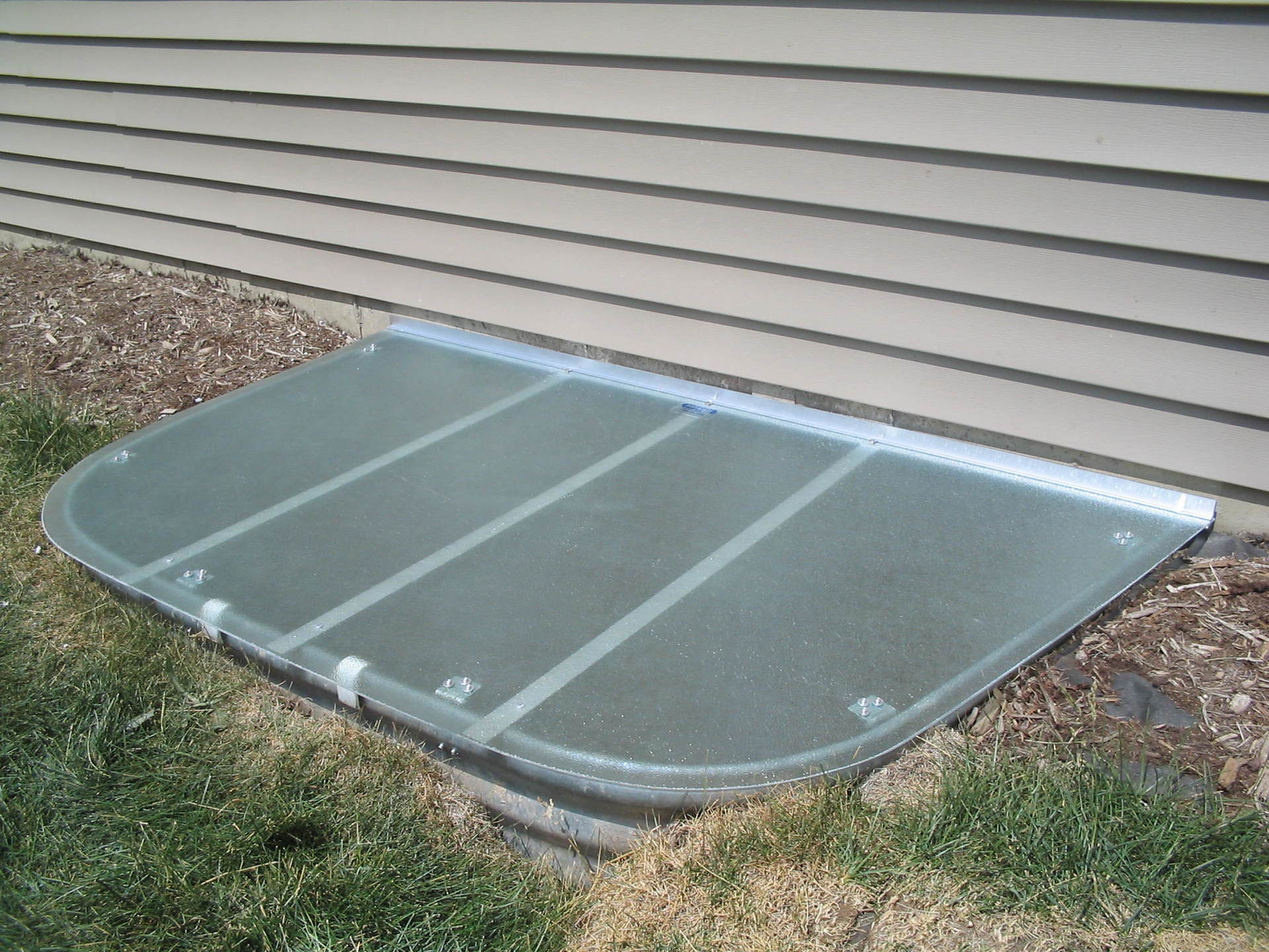 A window well with a clear glass cover on it