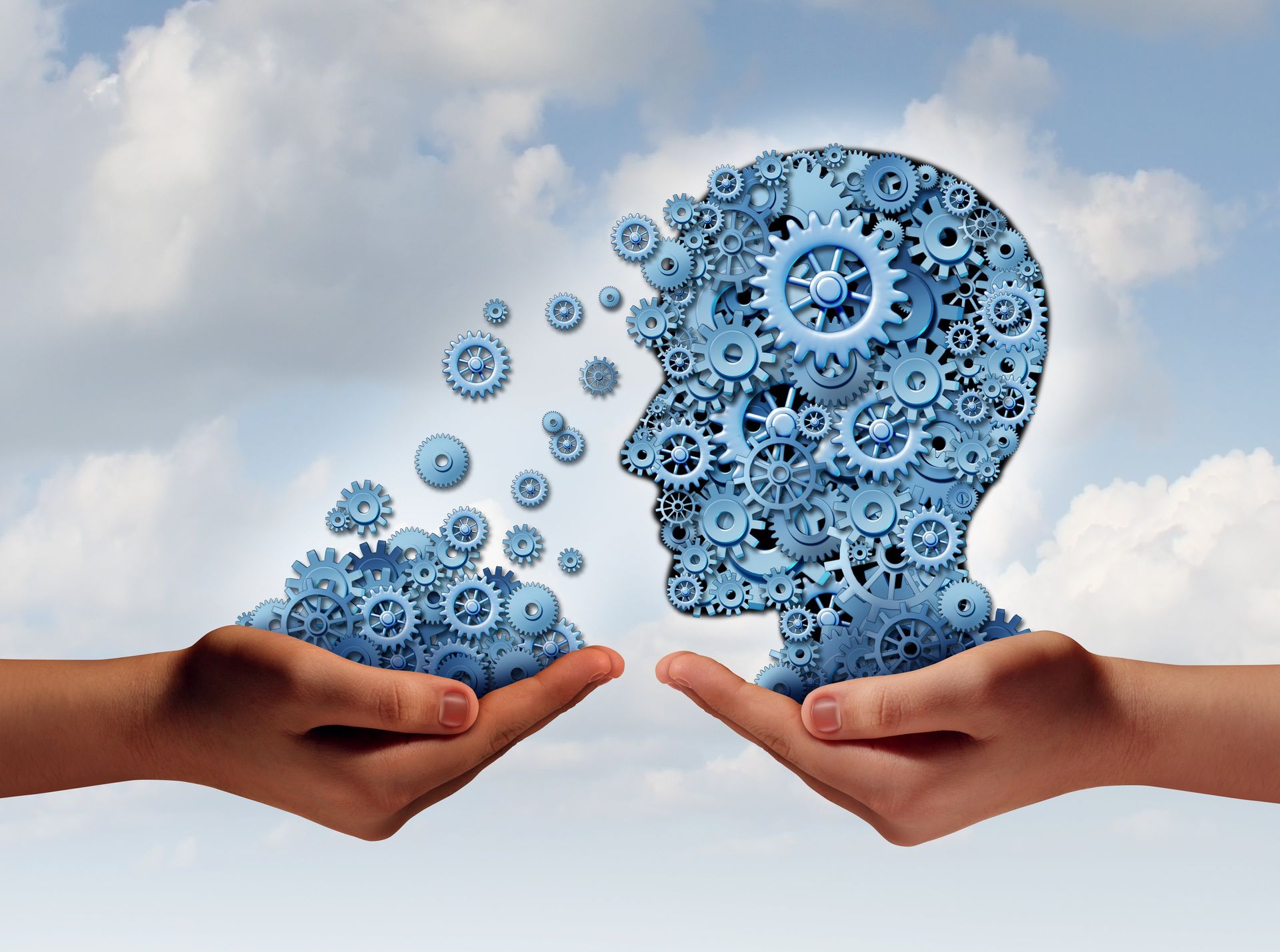 Training and development business education concept with a hand holding a group of gears transferring the wheels to a human head made of cogs as a symbol of acquiring the tools for career learning.