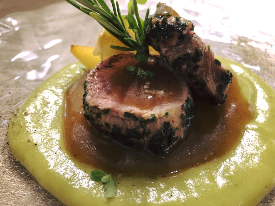 Medaglione di carne scottato su purea verde con salsa bruna e guarnizione di rosmarino