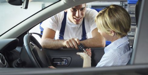 A woman picking up her car from the car towing service