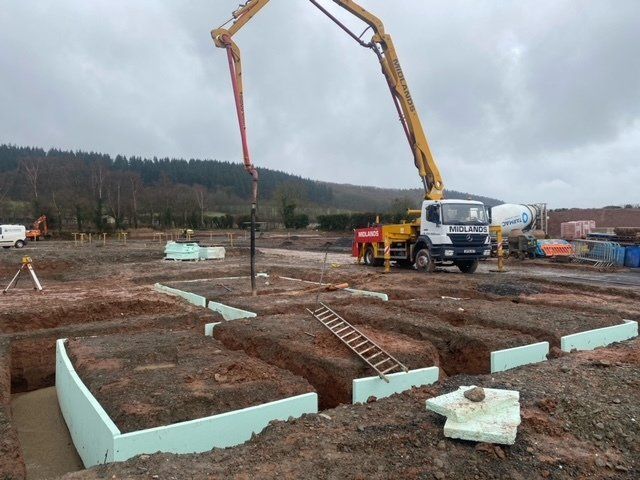 London deep foundations for new office block under construction showing ready mix concrete placement by pump from flexible hose