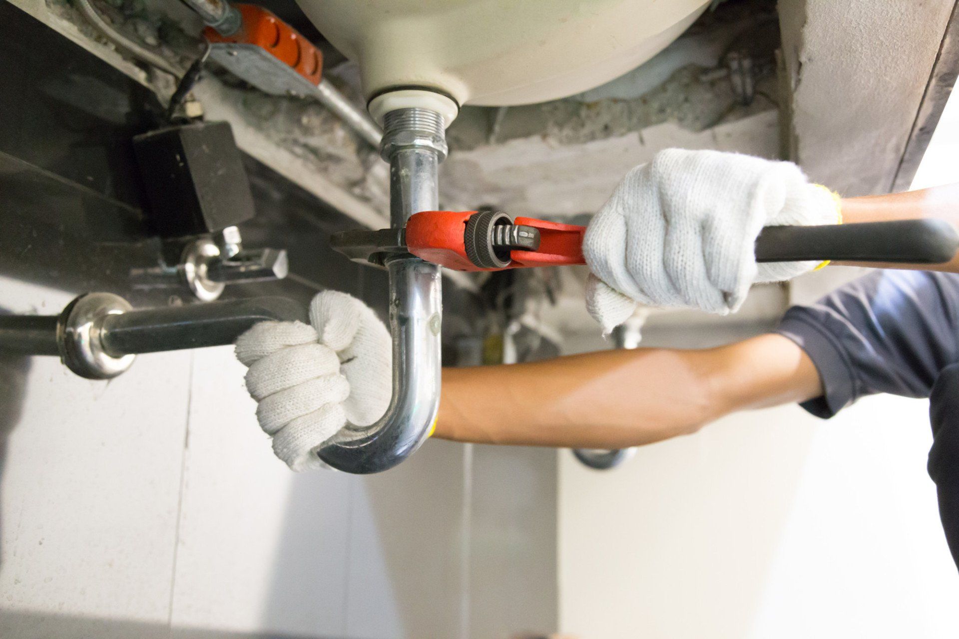 plumber holding pipe with wrench