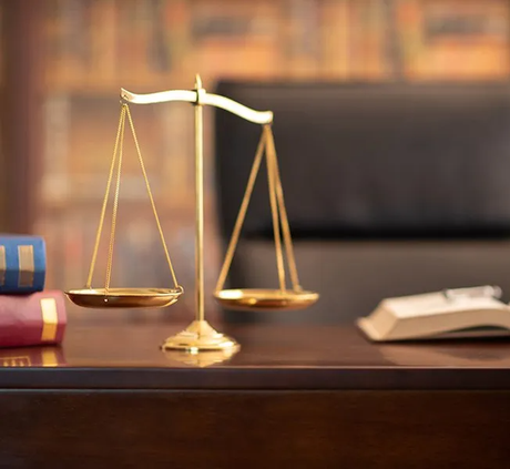 Justice Scales And Law Books On Desk — Hartland, WI — Langer & Peterson LLC