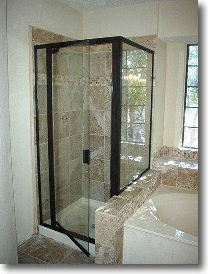 Shower next to tub with marble tiling tan and checkered strip
