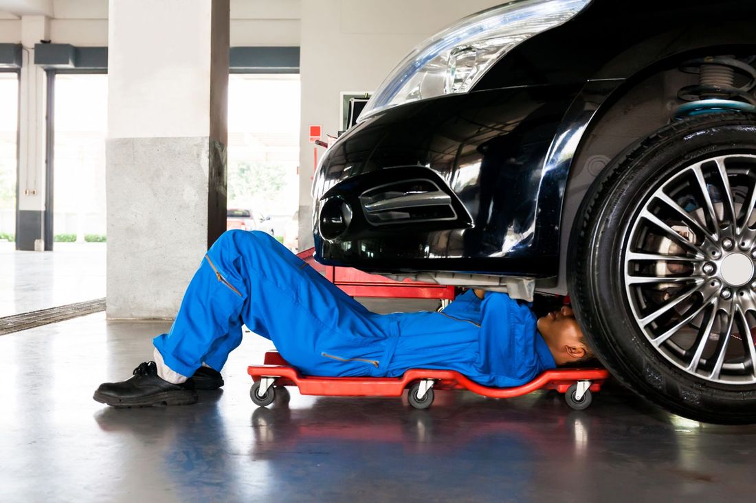 meccanico in officina mentre ripara una vettura