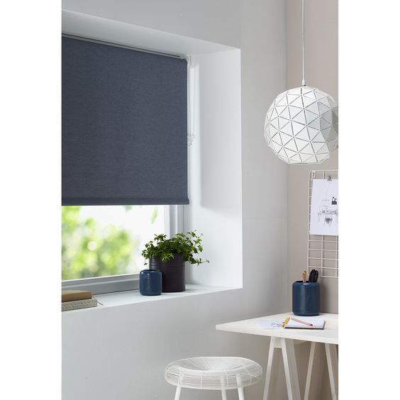 Een kamer met een raam, een bureau en een lamp.
