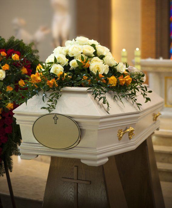White Coffin, wreath, candle in the Catholic Church