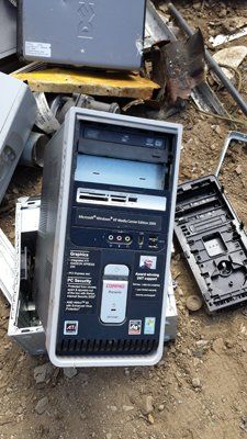 A computer tower is sitting on top of a pile of computer parts.